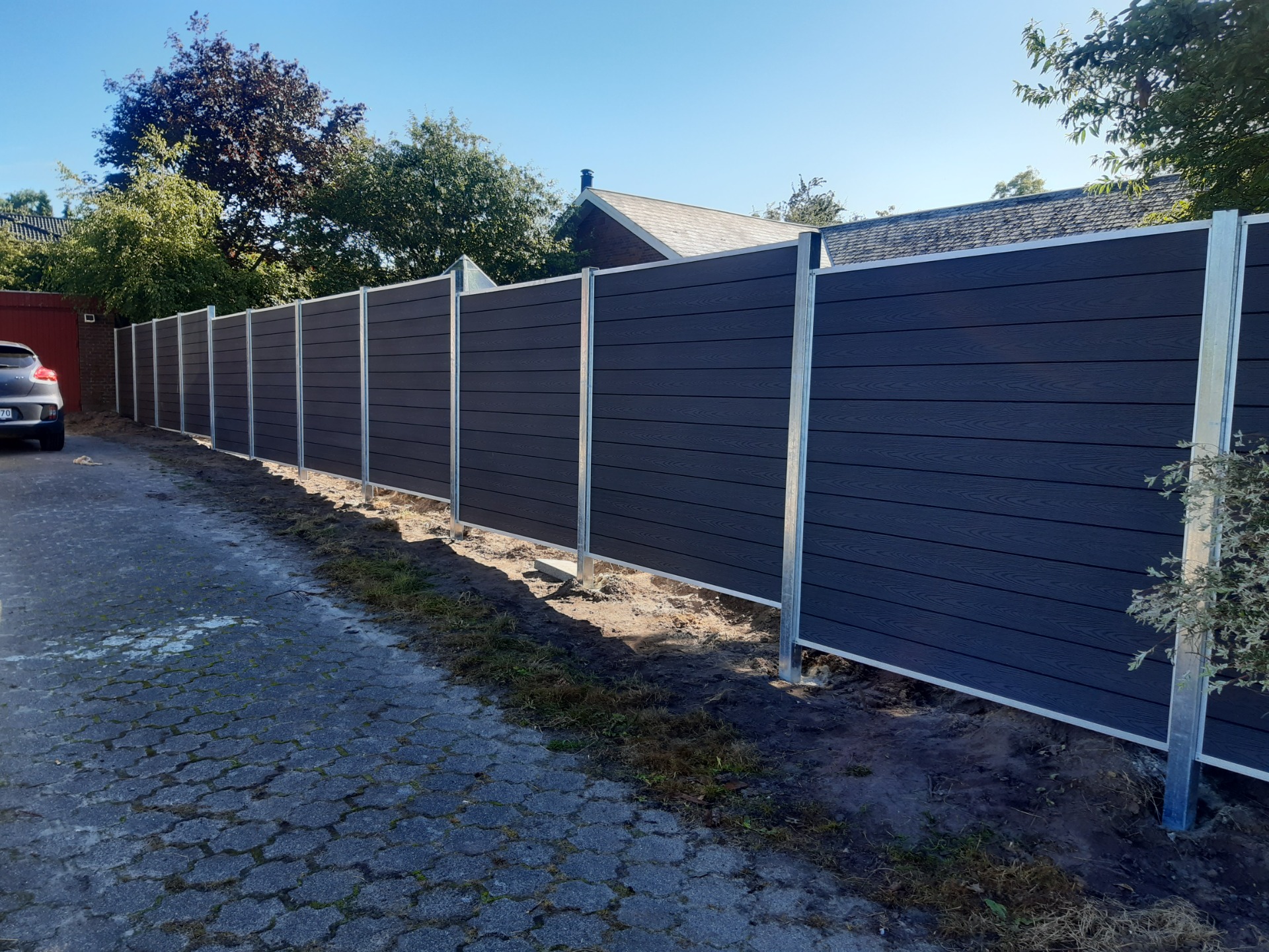 Sort træsommerhus med stort vindues parti